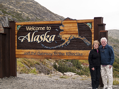 Bev and Jim at sign entering Alaska from Canada